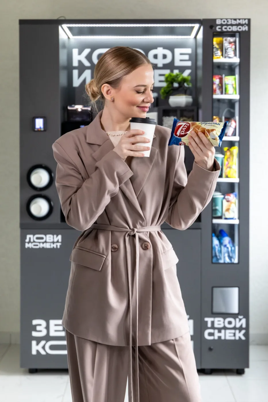 Сотрудница офиса берёт кофе и снек из автомата — самообслуживание без очередей